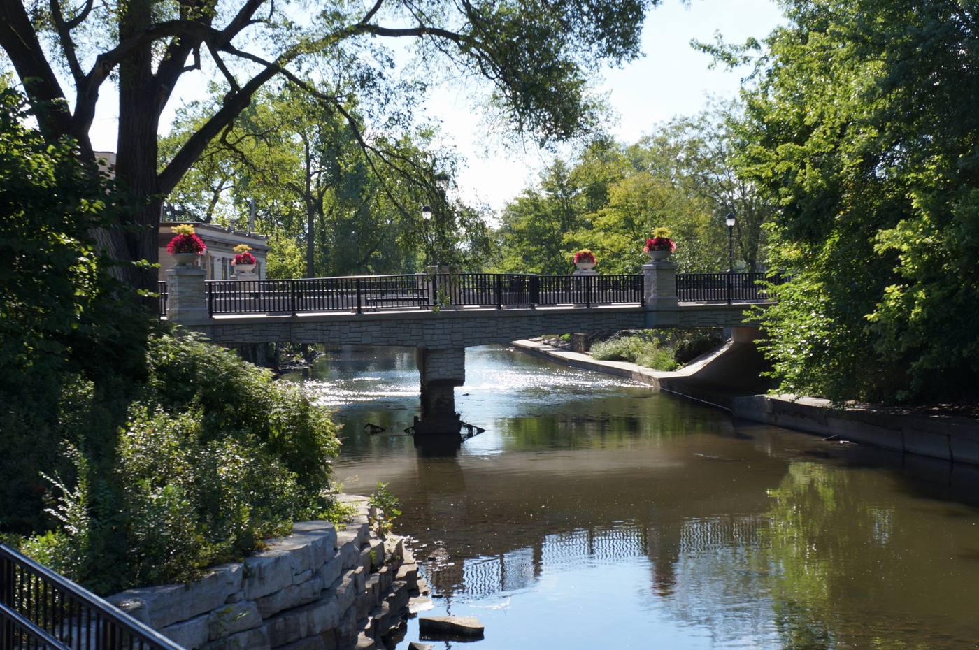 Stone bridge with flower planters over the DuPage River on the Naperville Riverwalk
